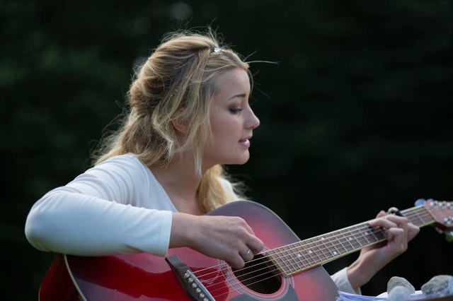 mladá žena hraje na kytaru